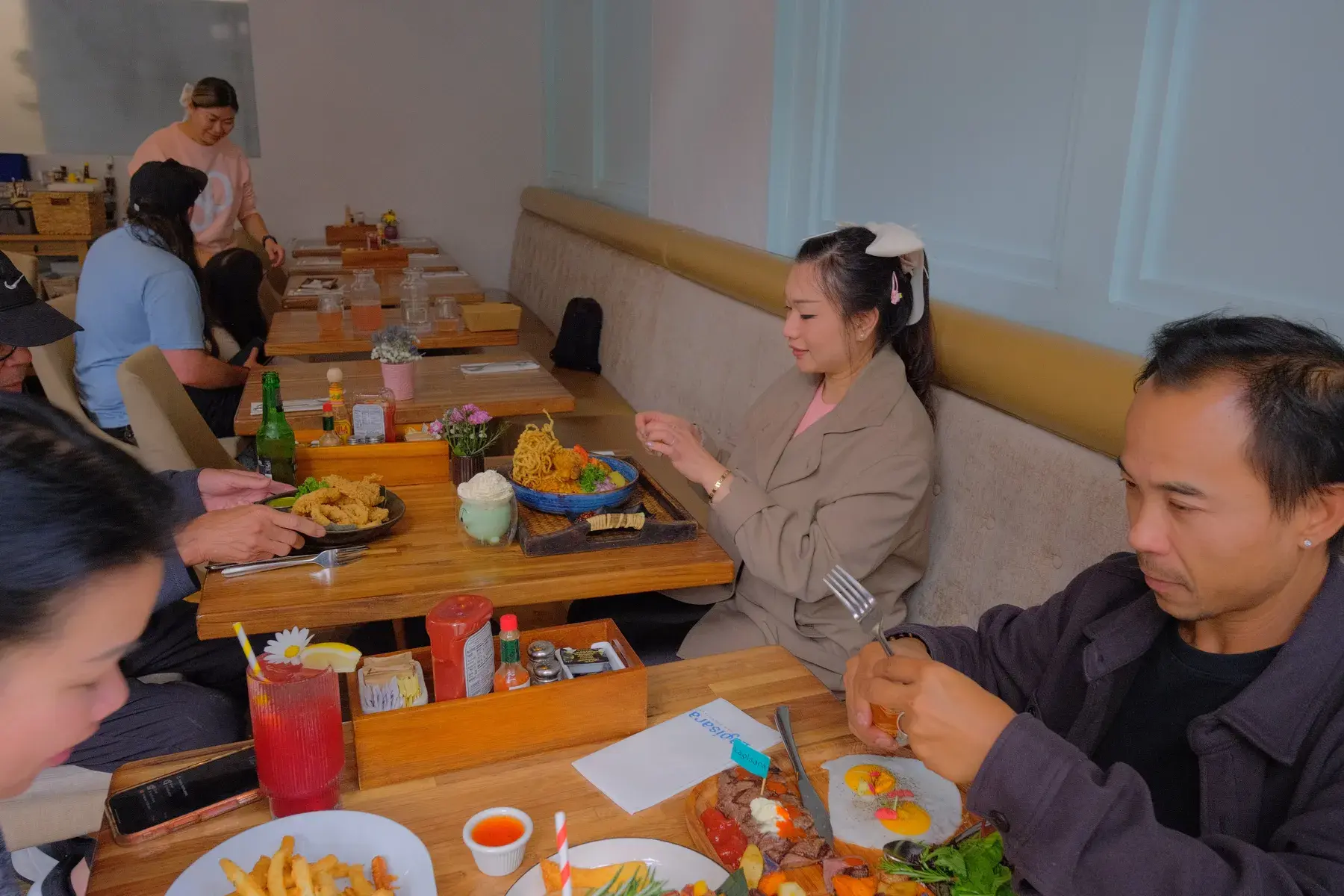 A couple at a booth with brunch plates and iced drinks between them